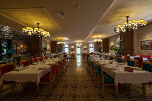 a dining room with tables and chairs and chandeliers at Grand Kadri Hotel - History Marked by Cristal Lebanon in Zahlé