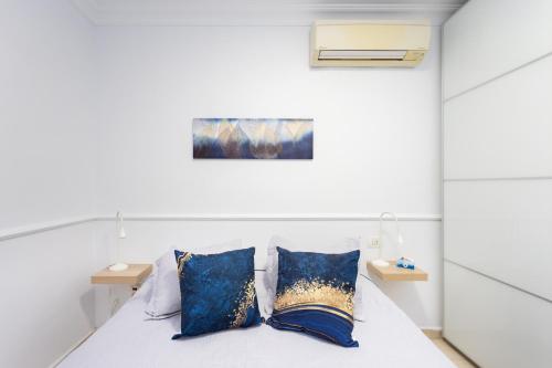 a bedroom with a bed with blue pillows at Home2Book Fantastic 160m2 Terrace Flat & BBQ in Radazul