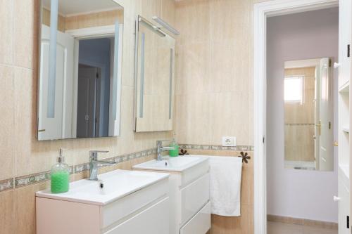 a bathroom with two sinks and two mirrors at Home2Book Fantastic 160m2 Terrace Flat & BBQ in Radazul