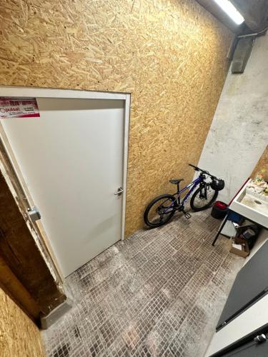 a bike parked next to a white garage door at loft 100m2 confort+. Chez Cédric et Jeza in Le Thillot