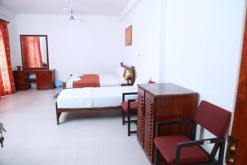 a bedroom with a bed and a table and chairs at Sea Shine Beach Hotel 