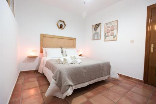 een slaapkamer met een bed met twee handdoeken erop bij Casa espaciosa cerca de Monachil in La Zubia