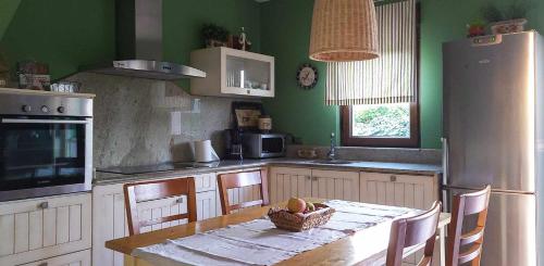 une cuisine avec une table avec un bol de fruits dessus dans l'établissement AG Casa Bértoa con jardín y comedor exterior x8, à Queo de Abaixo