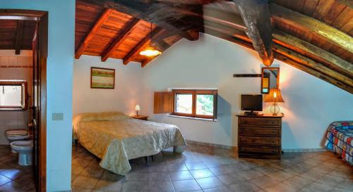 1 dormitorio con 1 cama en una habitación con techos de madera en Agriturismo La Ferrera en Varco Sabino
