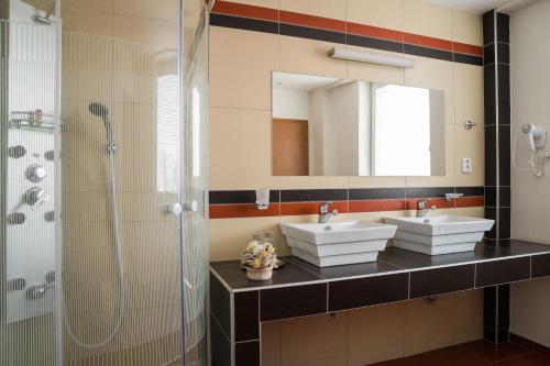 uma casa de banho com 2 lavatórios e um chuveiro em Hotel 21 em Bratislava