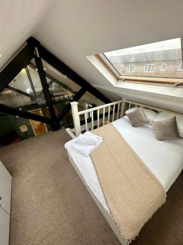 a bedroom with a bed with a large window at Reading City Centre - Business - Relocation - Luxury Apartment in Reading