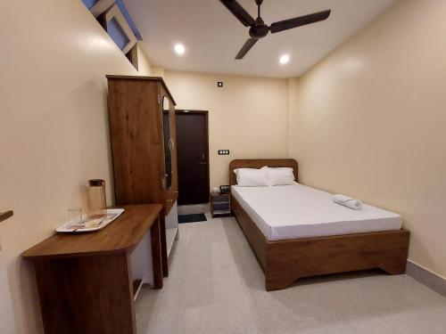 a bedroom with a bed and a desk in it at Hotel Hari Gayatri Regent in Guwahati