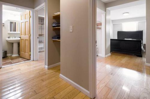 an empty room with a hallway with a bathroom and a sink at Two DC Rowhouses Large Groups Sleeps 21 in Washington, D.C.