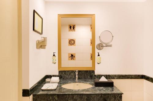 bagno con lavandino e specchio di Lemon Tree Hotel, Indore a Indore