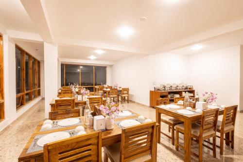 Aroha Residency- A Countryside Resort في مانالي: غرفة طعام كبيرة مع طاولات وكراسي خشبية