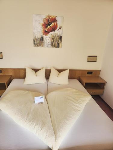 a bed in a room with a picture on the wall at Pension Grein in Pfunds