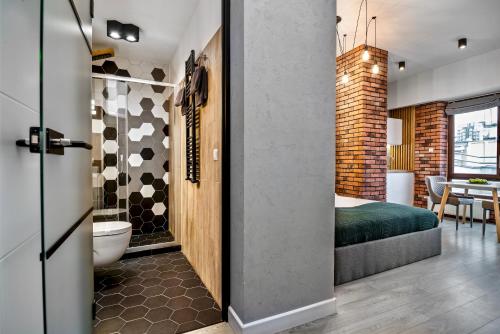 a room with a bedroom and a bathroom with a bed at NeatSpace - Ruska Center in Wrocław