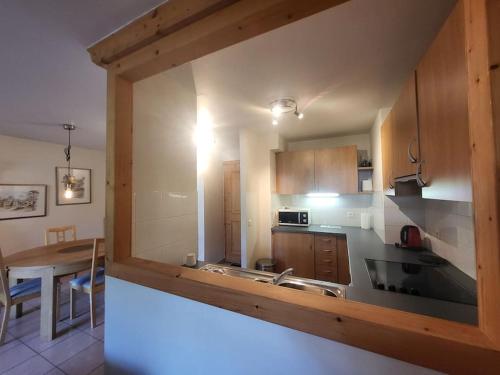 - une cuisine avec des placards en bois et une table à manger dans l'établissement A1/2, 3 bedroom apartment next to the ski lift, à Samoëns