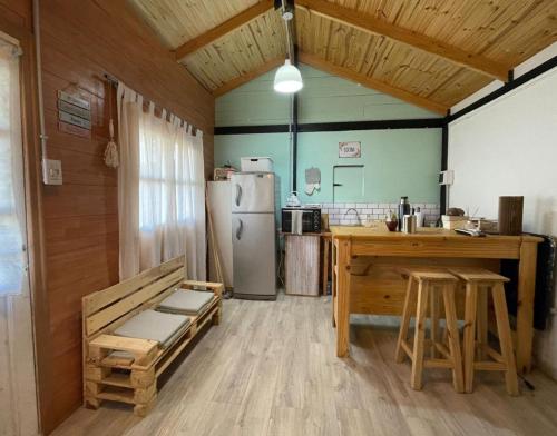 a kitchen with a refrigerator and a table and a counter at Nomade Mountain House in Potrerillos