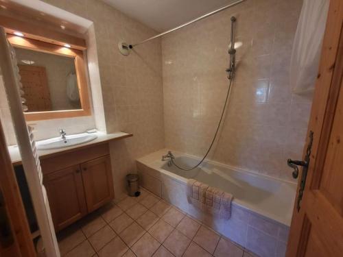 une salle de bain avec une baignoire et un lavabo dans l'établissement A1/2, 3 bedroom apartment next to the ski lift, à Samoëns