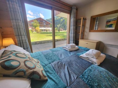 - une chambre avec un lit avec deux oreillers et une fenêtre dans l'établissement A1/2, 3 bedroom apartment next to the ski lift, à Samoëns