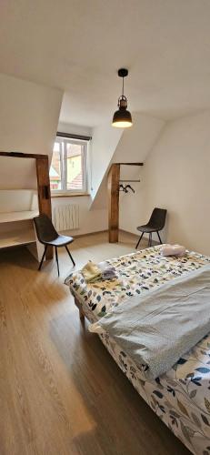 - une chambre avec un lit et deux chaises dans l'établissement Corps de ferme traditionnel, à Lembach