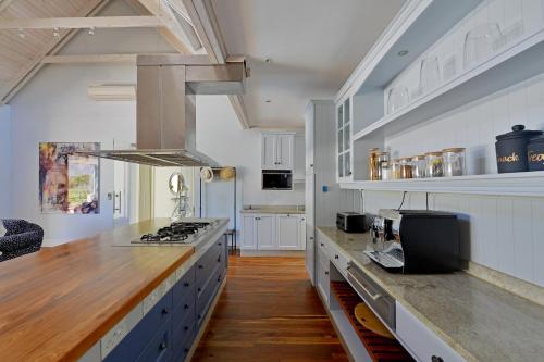 a large kitchen with white cabinets and a stove at Fransvliet Guest House in Franschhoek