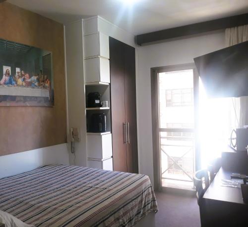 南聖卡埃塔諾的住宿－O Melhor Apart-Hotel, da Cidade!，一间卧室配有一张床,一扇门设有窗户