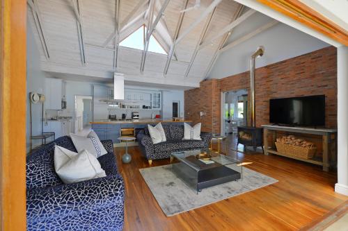 a living room with a couch and a tv at Fransvliet Guest House in Franschhoek