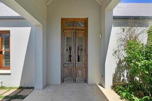 a wooden door of a white house with at Fransvliet Guest House in Franschhoek