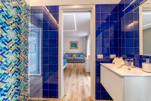 a bathroom with blue tiled walls and a sink at REGINNA LIGHTHOUSE in Maiori