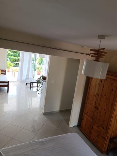 a room with a ceiling fan and a wooden door at Suite parentale Villa au bord de la mer chez Saloua in Bouéni