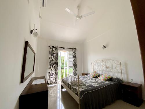 a bedroom with a bed and a window at Jas - Sri Lankan Villa in Polgasowita