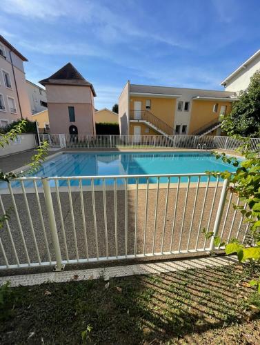 une clôture autour d'une piscine dans un bâtiment dans l'établissement Appartement avec place de parking et piscine, à Villefranche-sur-Saône