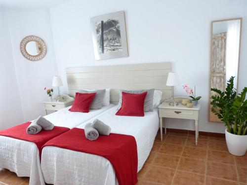 een slaapkamer met een groot wit bed met rode kussens bij Villa Alto Arena piscina privada climatizada in Ingenio