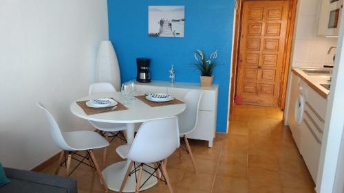 a kitchen with a white table and white chairs at Casa Las Torres 209 in Costa de Antigua