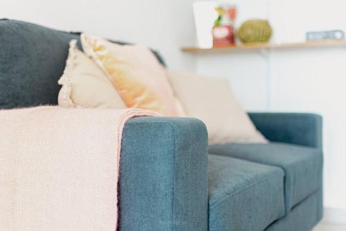 a blue couch with pillows in a living room at La casa tropicale in Le François