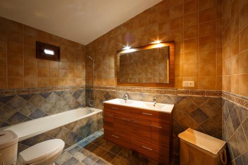 a bathroom with a sink and a tub and a toilet at villa chopo in Alhama de Granada