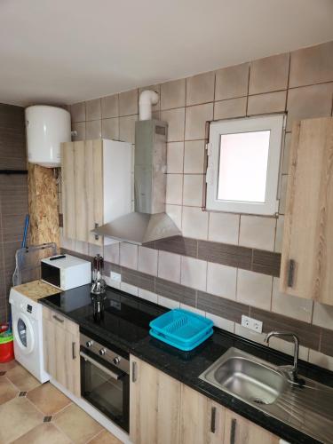 eine Küche mit einer Spüle und einer Arbeitsplatte in der Unterkunft Casa económica Madrid in Leganés