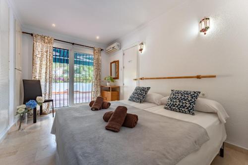 ein Schlafzimmer mit einem großen Bett mit zwei braunen Handtüchern darauf in der Unterkunft MalagaSuite Blue Paradise House in Benalmádena