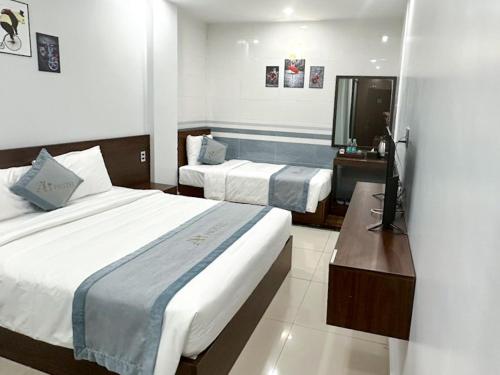 a hotel room with two beds and a television at AUI Hotel 38 Máy Tơ in Ðoan Xá