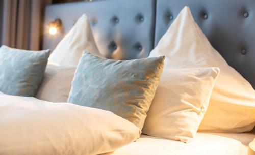 un mucchio di cuscini seduti su un letto di YORS Boutique Hotel ad Hannover