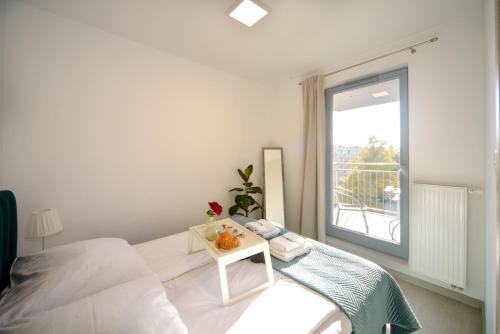 Habitación blanca con cama y ventana en Maya's Apartments, en Gdansk