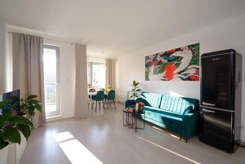 - un salon avec un canapé bleu et une table dans l'établissement Maya's Apartments, à Gdańsk