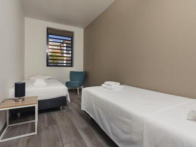 een hotelkamer met 2 bedden en een stoel bij MaJa appartement Bonaire in Kralendijk