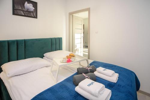 a bed with towels and a table on it at Maya's Apartments in Gdańsk