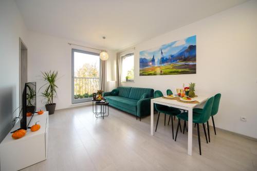 a living room with a green couch and a table at Maya's Apartments in Gdańsk
