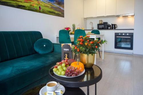 a living room with a table with a bowl of fruit at Maya's Apartments in Gdańsk