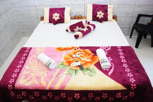 uma cama com um cobertor e almofadas em Aryan residency em Māvalli