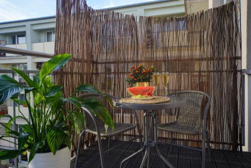 a table and chairs on a balcony with a fence at Maya's Apartments in Gdańsk