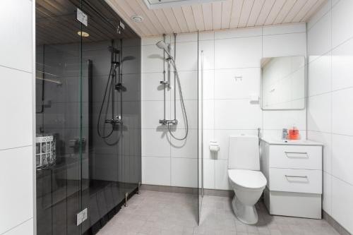 La salle de bains blanche est pourvue d'une douche et de toilettes. dans l'établissement Himoskuutio 9, erillistalo, ulkoporeallas, à Jämsä