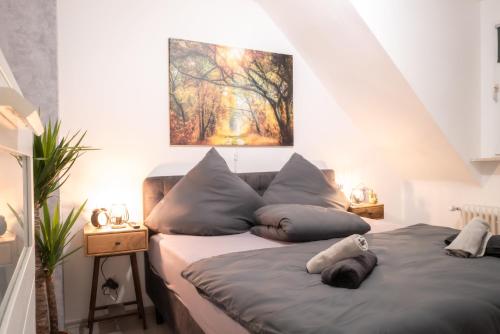 a bedroom with a bed with pillows and a painting at #413 Gemütliche Wohnung mitten im Ruhrpott in Mülheim an der Ruhr