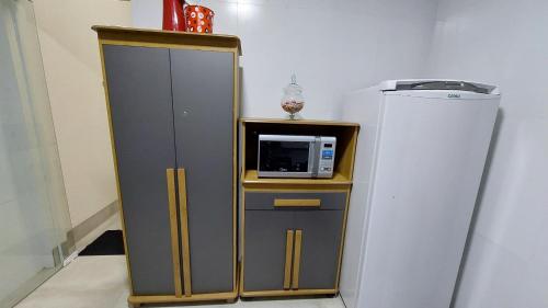 um armário com um micro-ondas e um frigorífico em Bela casa nova na Chapada dos Guimarães em Chapada dos Guimarães