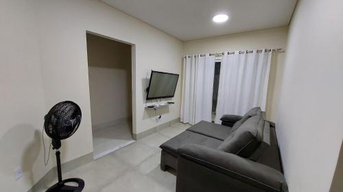 uma sala de estar com um sofá e uma televisão de ecrã plano em Bela casa nova na Chapada dos Guimarães em Chapada dos Guimarães