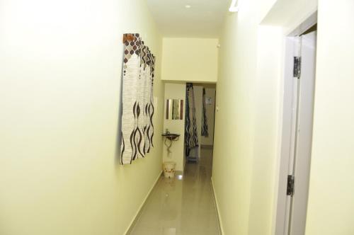 a hallway with a painting hanging on a wall at Srirangam Homestay in Srīrangam